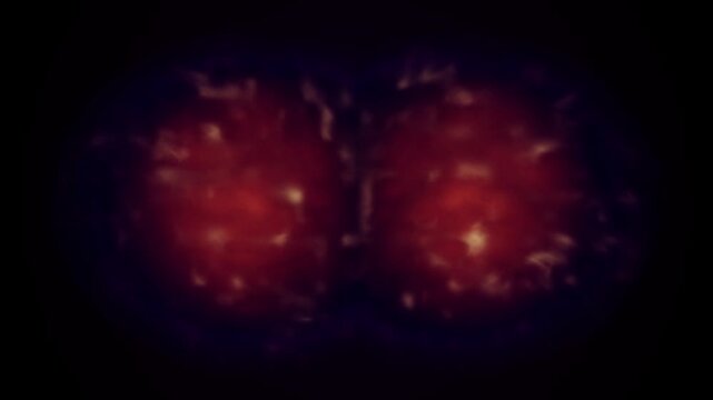 Abstract cell division animation with glowing red mitosis on dark background