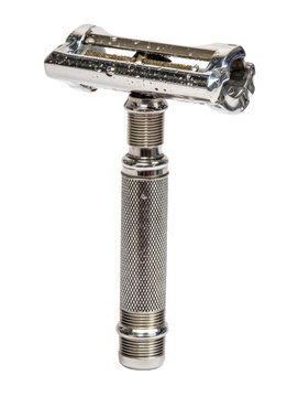 A detailed studio shot of an antique double-edged safety razor, showcasing its metallic sheen and intricate design elements