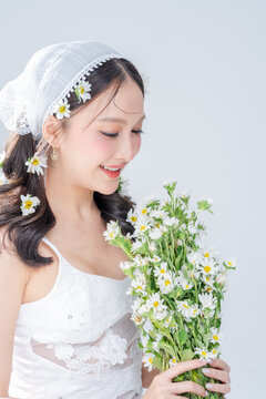 Dreamy radiant woman holding daisy bouquet close with pure joy, embracing gentle botanical skincare beauty, hopeful longing, romantic affection, spring bliss, and pristine youthful freshness.
