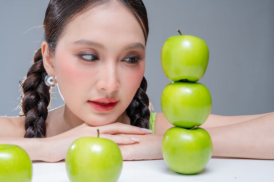 Radiant cheerful woman holding fresh green apple, expressing healthy lifestyle, organic diet vitality, dental beauty, wellness balance, joyful nutrition, natural freshness, and vibrant body detox.