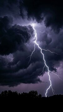 Spectacular flash of lightning striking the ground from dark storm clouds at night