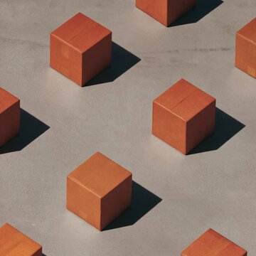Orange corrugated parcels arranged in a clean pattern on a graphite grey surface, featuring hard shadows for a commercial mockup background