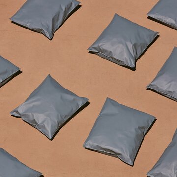 Sealed slate grey ballot transfer bags arranged in a repetitive pattern on warm concrete for election day and voting concepts