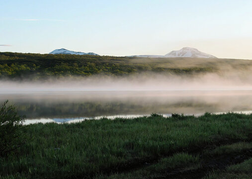 A lake in the early morning with rising fog