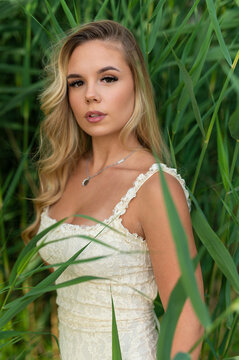Blonde woman posing in lush green reeds