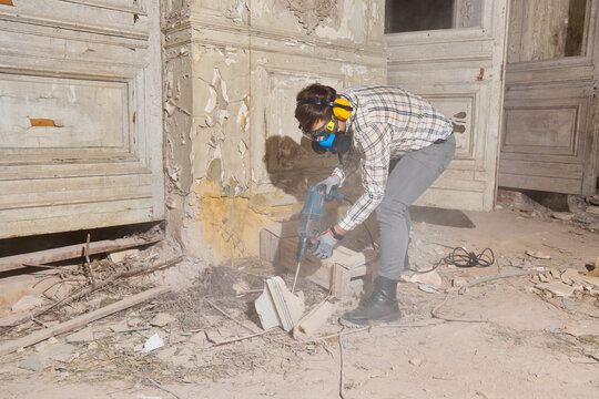 Manual laborer utilizes pneumatic tool for surface destruction purposes