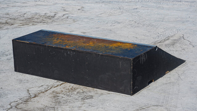 Portable skate park box featuring a ramp end and weathered wooden surface for grinding and skateboarding tricks.
