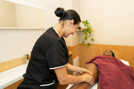 Therapist performing professional massage treatment on client's leg