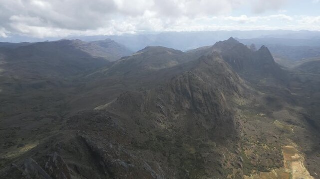 Aerial drone view of the high-altitude Sumapaz Paramo ecosystem in Colombia featuring native frailejon plants, glacial lakes, and rugged Andean mountains.