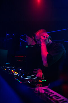 DJ Performing Live in a Club at Night With Colorful Lights