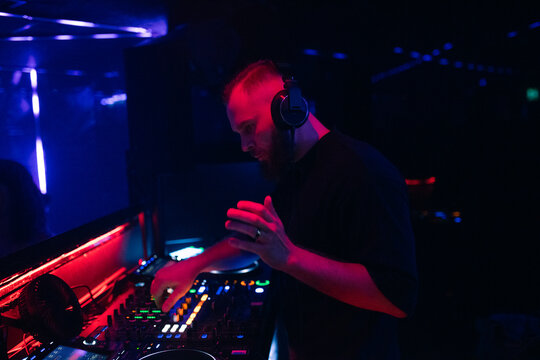 Focused DJ playing music at nightclub