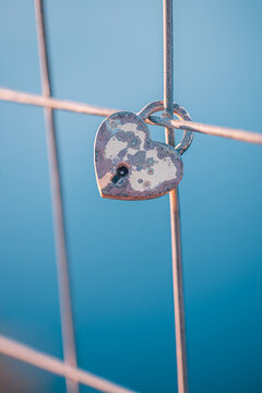 Romantic love padlock heart shaped lock fence blue sky symbol eternal love couples valentine commitment. Conceptual love travel scene. Wedding anniversary romance couples devotion symbol background