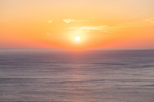 Dreamy golden sunset calm sea glowing orange sky soft clouds tropical horizon evening summer ocean water. Peaceful summer sunset scene nature. Romantic relaxing meditation coastal wellbeing background