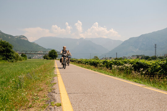Senior woman cycling on alpine bike path in northern Italy