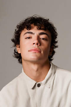 Young Man Poses in a Studio With a Neutral Background