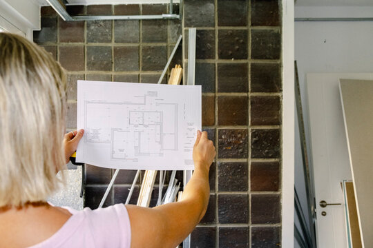 Architect reviewing floor plan at renovation site