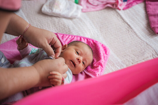 Parent dressing newborn infant for daily routine