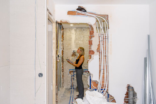 Architect checking plumbing and wiring at renovation site