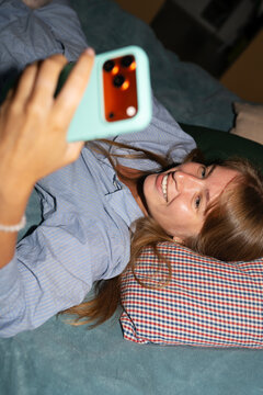 Woman with a mobile phone in bed