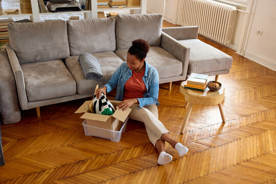 Woman browse a box of personal items in the living room