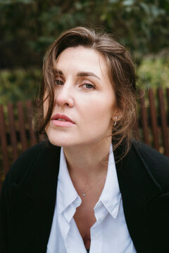 Woman With Expressive Gaze Outdoors in a Serene Garden Setting