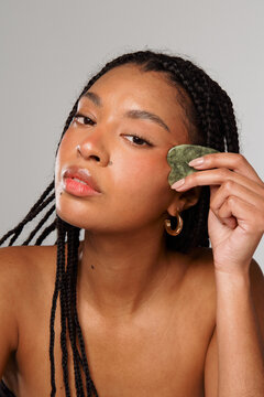 Woman Using Jade Roller for Facial Care at Home