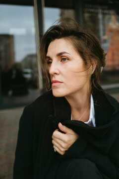 Woman Lost in Thought on a City Street During a Gray Day