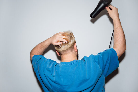 Young Man Blow Drying Bleached Hair from Behind