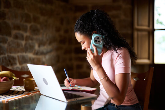Young woman working from home taking phone call
