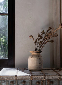 Wooden vase with dried flowers interior background vignette