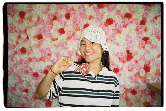 Portrait of Smiling Woman Holding Colorful Lollipop
