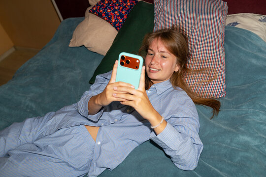 Woman with a mobile phone in bed