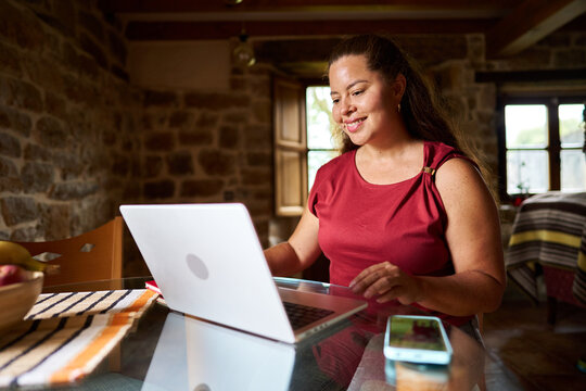 Woman working remotely at home using laptop