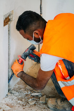 Contractor chiseling wall for electrical wiring