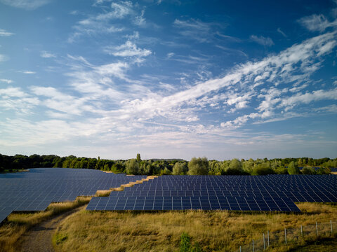 Solar Panel Field Under Blue Sky With Clouds