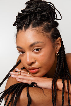 Woman With Braids Resting on Arms in a Studio Setting