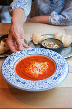 Woman enjoying cold tomato soup and lebanese food