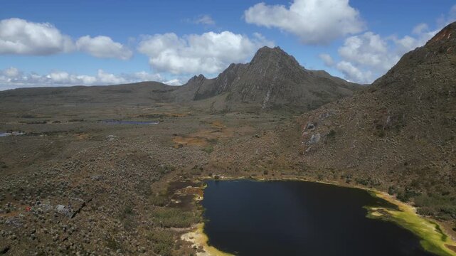 Aerial drone view of the high-altitude Sumapaz Paramo ecosystem in Colombia featuring native frailejon plants, glacial lakes, and rugged Andean mountains.