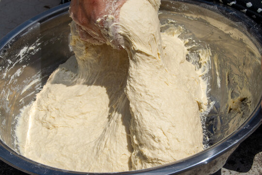Close-up of Woman Kneading Dough by Hand in Metal Bowl