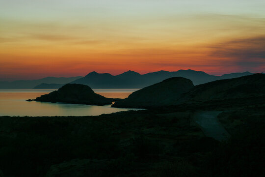 Quiet early pre dawn sunrise with colorful sky over Aegean Sea at Mandrakia village on Greek island Milos in Greece.
