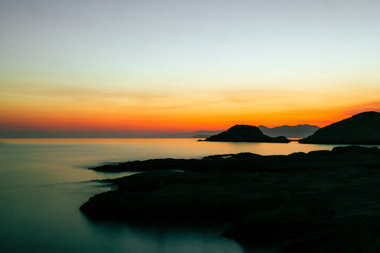 Quiet early pre dawn sunrise with colorful sky over Aegean Sea at Mandrakia village on Greek island Milos in Greece.