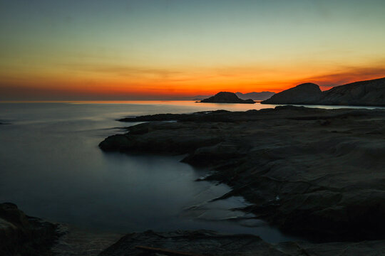 Quiet early pre dawn sunrise with colorful sky over Aegean Sea at Mandrakia village on Greek island Milos in Greece.