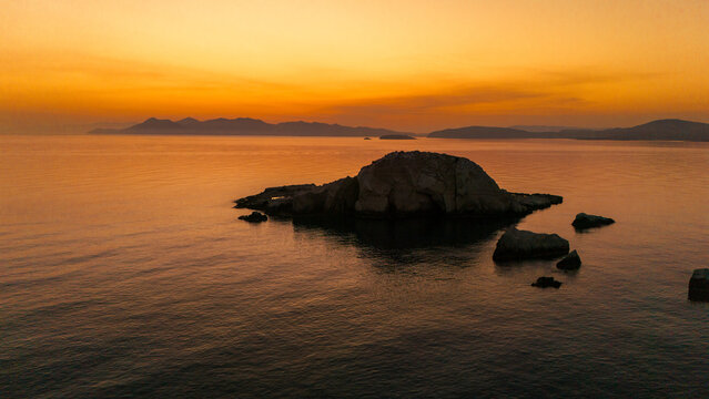 Quiet early pre dawn sunrise with colorful sky over Aegean Sea at Mandrakia village on Greek island Milos in Greece.