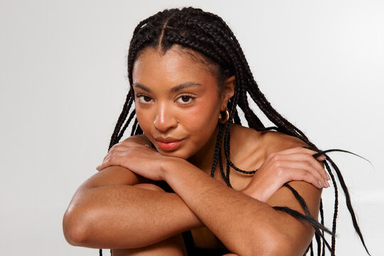 Young Woman Poses With Braided Hair in Studio Setting