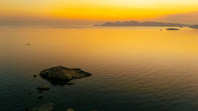Quiet early pre dawn sunrise with colorful sky over Aegean Sea at Mandrakia village on Greek island Milos in Greece.