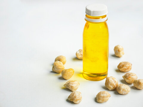 Candlenut oil extract in a small bottle against a white background.