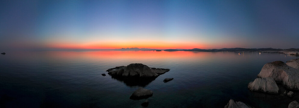 Quiet early pre dawn sunrise with colorful sky over Aegean Sea at Mandrakia village on Greek island Milos in Greece.