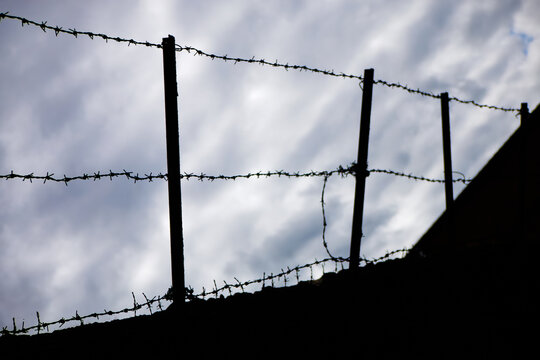 A silhouette of barbed wire against a cloudy sky - Wolverhampton, UK