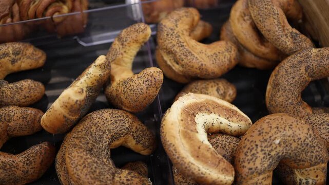 Fresh poppy seed rolls fill a supermarket bakery display with golden crust and traditional crescent shapes offering baked goods for breakfast snacks and everyday shopping