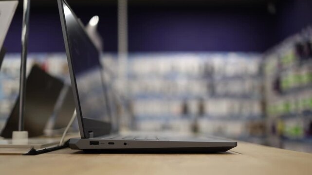 Modern laptop displayed open on a retail store table showing a slim portable design and connectivity ports for customers choosing new technology for work and everyday use
